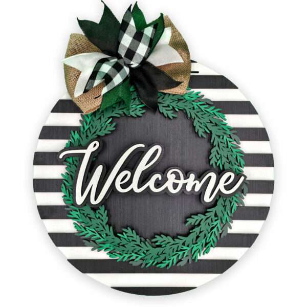 Decorative welcome sign with a black and white striped background, featuring a green wreath and the word "Welcome" in the center. Topped with a black and white checkered bow.