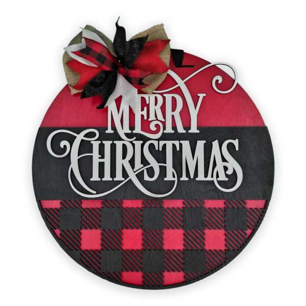 A round, festive Christmas sign with the words "Merry Christmas" in white script. The sign features a red and black plaid pattern on the bottom half, and is adorned with a decorative bow in red, black, and burlap colors at the top.