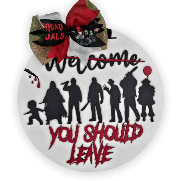 A white circular wreath showcasing seven black silhouette figures, including various Halloween-themed characters, with red accents. The top text "Welcome" is crossed out in red, while "You Should Leave" is written in bold red letters below. A festive bow adorns the top.