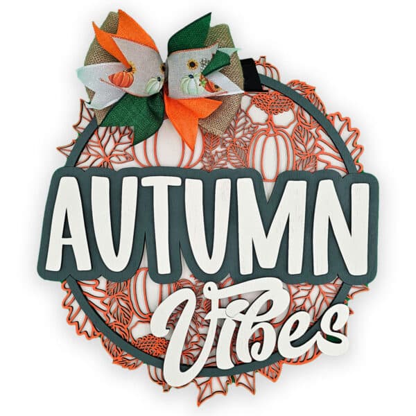 This decorative door sign features "Autumn Vibes" in white on a dark green backdrop. A vibrant bow, adorned with pumpkin illustrations in orange, brown, and green, crowns it. The background showcases orange and white patterns alongside charming pumpkins for a perfect seasonal touch.