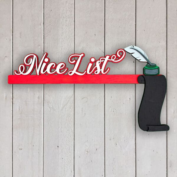 A decorative sign featuring the words "Nice List" in red cursive script, with a black scroll and a quill pen in an ink pot at the end, against a light wooden background.