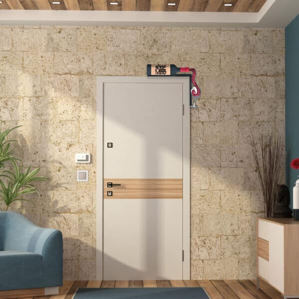 A modern living room with a light beige door featuring two-tone wood accents. The stone wall has a small colorful flag above the door, surrounded by a mix of furniture including a blue sofa, a cabinet, a plant, and decorative items.